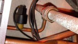 Czujnik i przewód w piecu Termet z osadem na rurce Zbliżenie na czujnik i metalową rurkę w piecu gazowym z widocznymi osadami