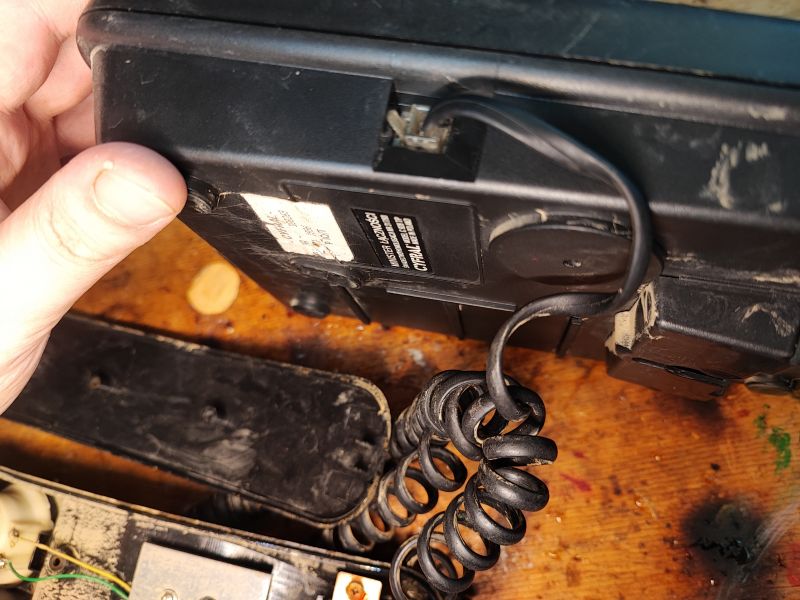 Wnętrze telefonu Cyfral C 928 T/P z lat 90. XX wieku z widocznymi komponentami i spiralnym kablem.