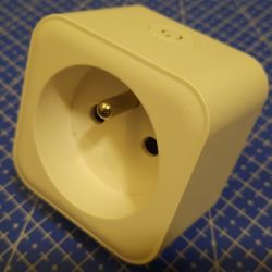 IMMAX NEO LITE Smart Plug Close-up of a white IMMAX NEO LITE smart plug on a blue measuring mat background.