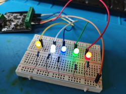 Five lit LEDs in different colors mounted on a breadboard with connecting wires