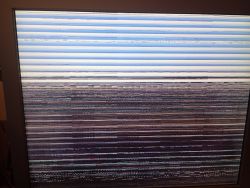 Ekran monitora z poziomymi pasami i zakłóceniami graficznymi na całej powierzchni