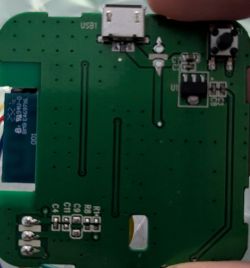 Close-up of a green PCB with a micro‑USB port, a small push button, and a ribbon labeled “SAMSUNG”