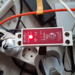 A device with a WiFi module by EARU, mounted on a power strip.