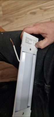 Osoba trzyma lampa LED z odłączonym przewodem.