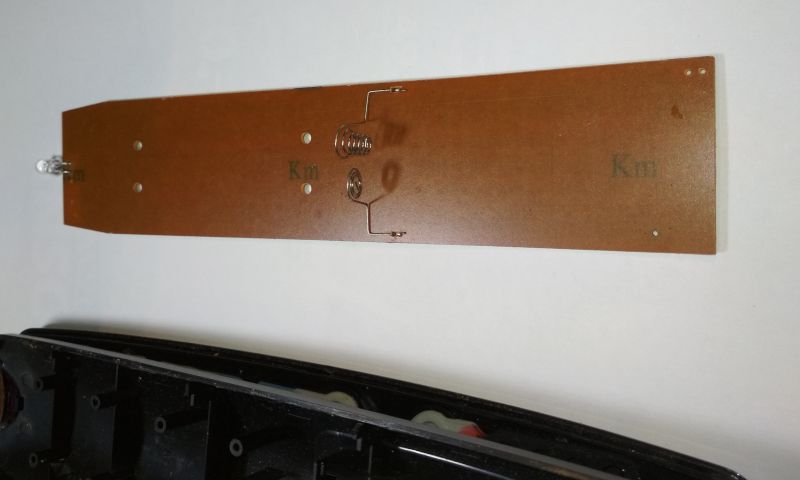 Wnętrze pilota do sprzętu RTV z widoczną płytką drukowaną i elementami sprężynowymi.