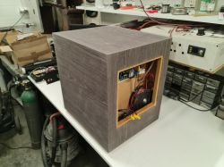 Domowy subwoofer DIY z szarym fornirem i otwartym panelem tylnym.