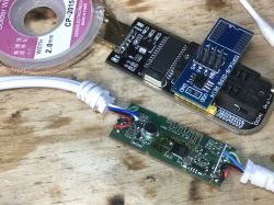 Components of the LED RGB Set with Controller and Programmer Adapter Electronic components of the LED RGB set on a wooden surface, including a controller board with attached cables and a programmer adapter.