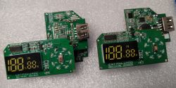 Dwie wersje płytek PCB z wyświetlaczami LED i portami USB, oznaczone jako CST-PNL-J400 Rev.1.01 i Rev.2.01.