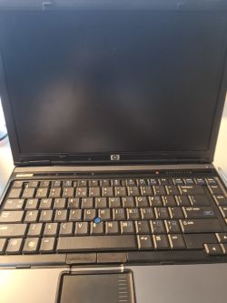 Laptop HP Compaq 6910p z czarnym ekranem i podświetloną klawiaturą.