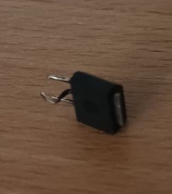 Element elektroniczny leżący na drewnianym blacie.