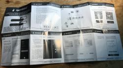 User manual for the Gembird TSL-PS-F4U-01-W power strip unfolded on a wooden surface.