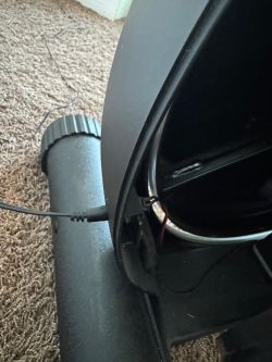 Nahaufnahme eines Netzkabels an Fitnessgerät auf Teppichboden