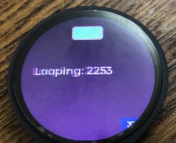 Okrągły wyświetlacz LCD ESP32-S3-Touch z widocznym tekstem „Looping: 2253” i ikoną baterii.