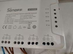 Close-up of a Sonoff 4CHPRO R3 relay panel showing R1–R4 terminals with NO, COM, and NC labels