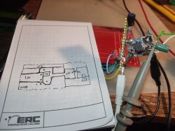Schemat inwertera na kartce papieru obok prototypu z Raspberry Pi Pico.
