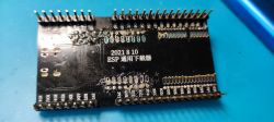 Close-up of a PCB with the text 2021 8 10 ESP 通用下载器 and soldered pins.