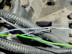 Zbliżenie na przewody w peszlu, z widocznymi złączami i odsłoniętymi końcówkami miedzi