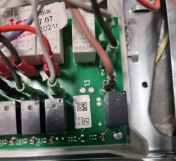 Zbliżenie na płytkę drukowaną piekarnika Amica z widocznymi przewodami i elementami elektronicznymi.