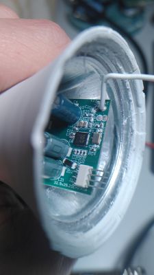 Close-up of a circuit board inside a casing with visible capacitors and a connector.
