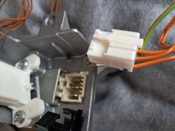 Zbliżenie na podłączenie elektryczne silnika z pralki z wtyczkami i kablami.