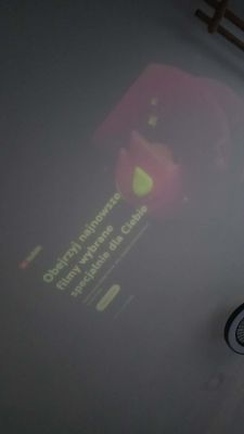 Słaby, wyblakły obraz z projektora; niewyraźny ekran z polskim tekstem i grafiką kropli