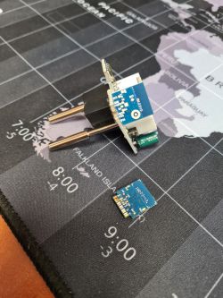 ESP-02S module mounted on an electrical plug lying on a map mat.