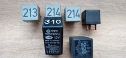 Różne przekaźniki samochodowe z numerami 213, 214, 310 i oznaczeniami firmowymi VW i Audi na drewnianym tle.
