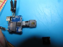 Electronic module with detached lens on a blue background.