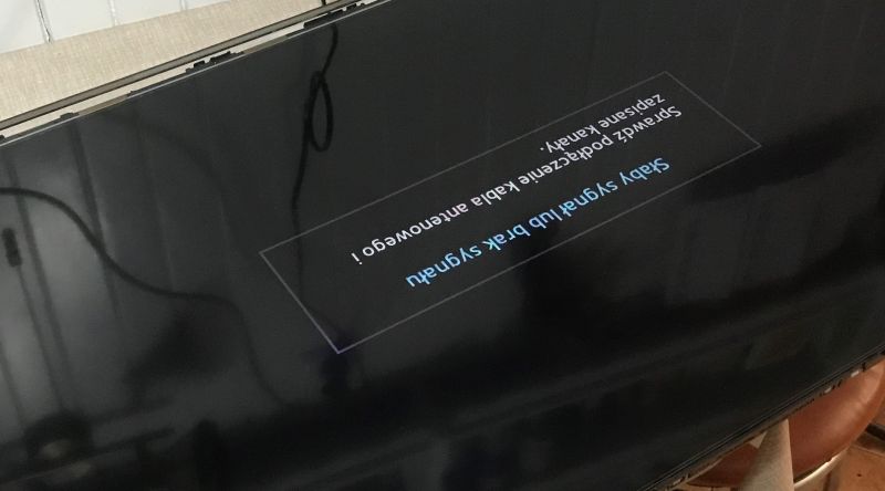 TV with No Signal Message and Dimmed Screen Photo of a TV screen with a no signal message and visible dimming.