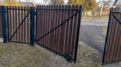 Otwarte drewniane bramy skrzydłowe z metalową ramą.