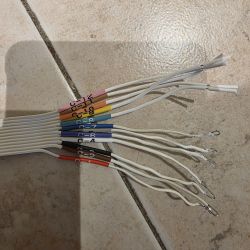 Zestaw oznaczonych przewodów elektrycznych z końcówkami na kafelkowej podłodze