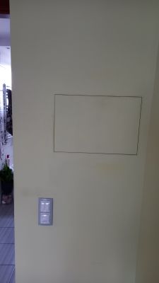 Inspection hatch on a wall with a light switch Photo of a wall with a rectangular inspection hatch and a double light switch below.