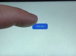 Touching the Click Me Button on Waveshare ESP32-S3-Touch-LCD-5 Display An index finger touches a blue button labeled Click Me on a touchscreen display.