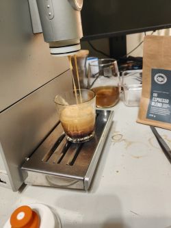 Ekspres do kawy nalewający espresso do szklanki na stalowej tacy ociekowej