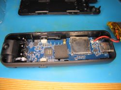 Interior of a portable electronic device with exposed PCB Circuit board with electronic components inside a portable device housing
