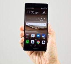 Smartfon Huawei trzymany w dłoni z widocznym ekranem głównym