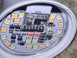 Close-up of the inside of a light bulb with a BZ2L module and BL702 microcontroller, surrounded by LED lights.