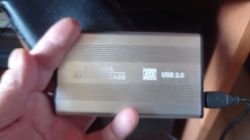 Rozmazane zdjęcie zewnętrznego dysku twardego 2.5'' w obudowie USB 2.0, trzymanego w ręce.