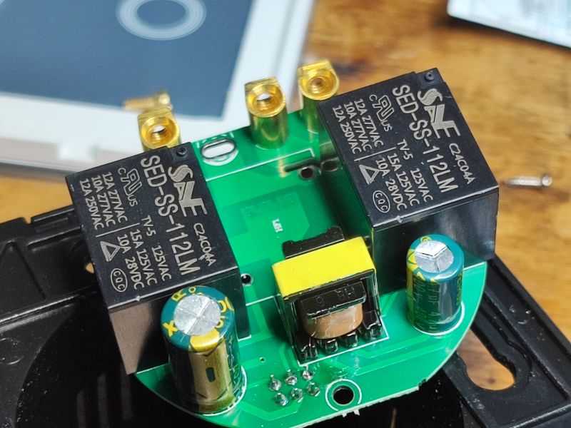 Wnętrze elektroniczne włącznika WiFi z widocznymi dwoma przekaźnikami.