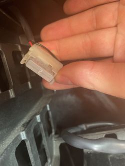 Kabel z czerwonym i czarnym przewodem oraz bezpiecznikiem 2A w dłoni.