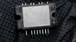 Moduł elektroniczny z wieloma nóżkami na ciemnym tle.