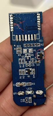Image of a printed circuit board (PCB) held in hand with marked components.