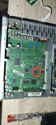 Wnętrze urządzenia z płytką PCB; czerwone kółko zaznacza mały układ scalony na płycie