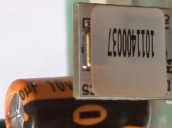 Close-up of electronic components, including a labeled capacitor and an integrated circuit.