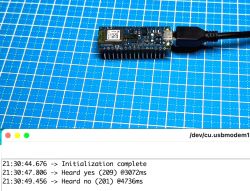 Arduino Nano 33 BLE Sense Lite podłączone przez USB, na tle niebieskiej maty, z oknem komunikacji szeregowej pokazującym wyniki rozpoznawania głosu.