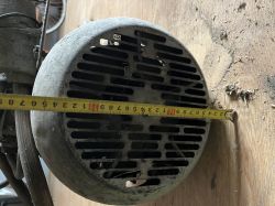 Obudowa metalowa urządzenia z kratką wentylacyjną, na której leży miarka wskazująca średnicę około 20 cm.