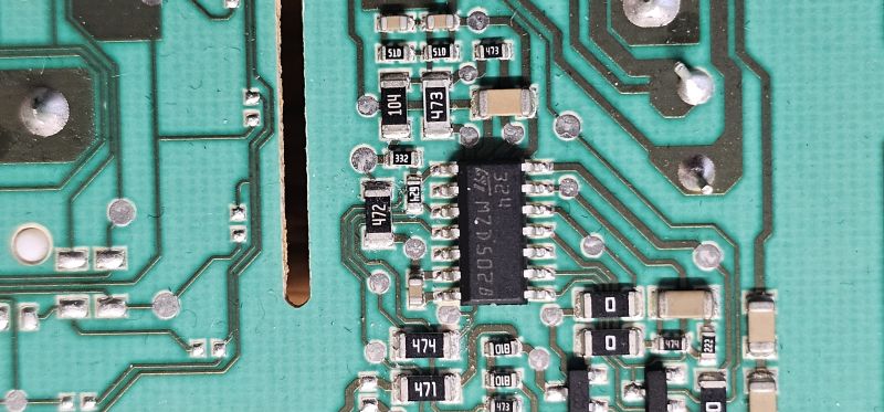 Zbliżenie na zieloną płytkę PCB z układem scalonym i podzespołami SMD