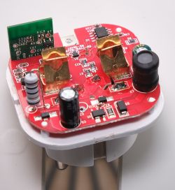 Close-up of a red circuit board with electronic components and relays.
