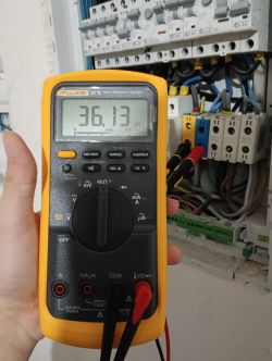Multimetr mierzący rezystancję w rozdzielnicy elektrycznej.
