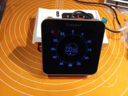 Elektroniczny minutnik z dużym ekranem LED na pomarańczowej powierzchni.